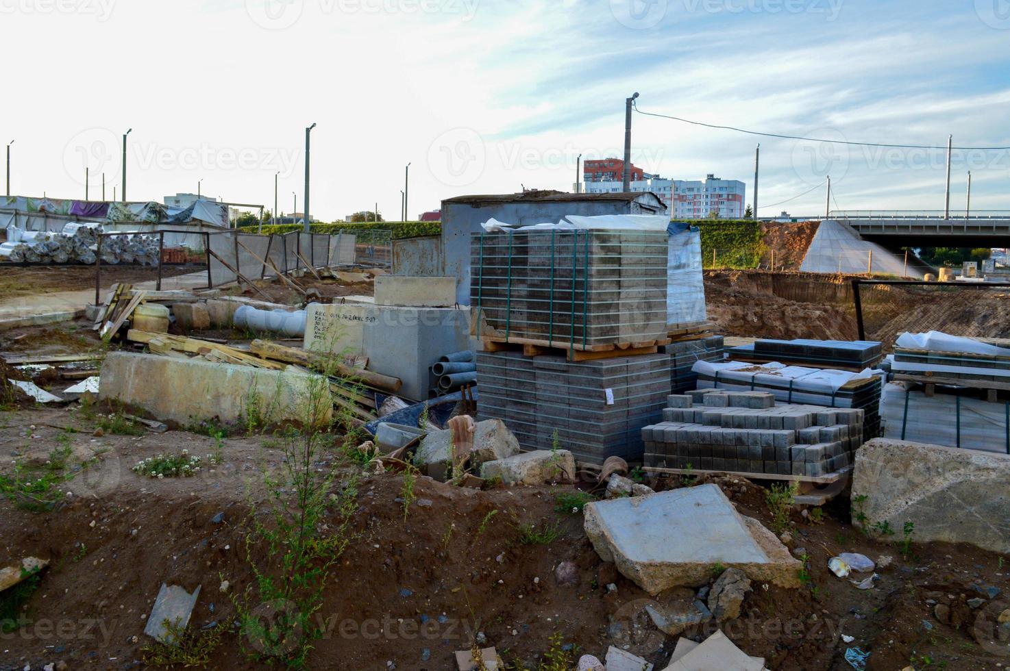 metselwerk voor de bouw van weg omslag. dichtbij zijn metaal pijpen, kegels en andere elementen van de bouw plaats. gedekt gebouw materialen tegen de blauw lucht foto