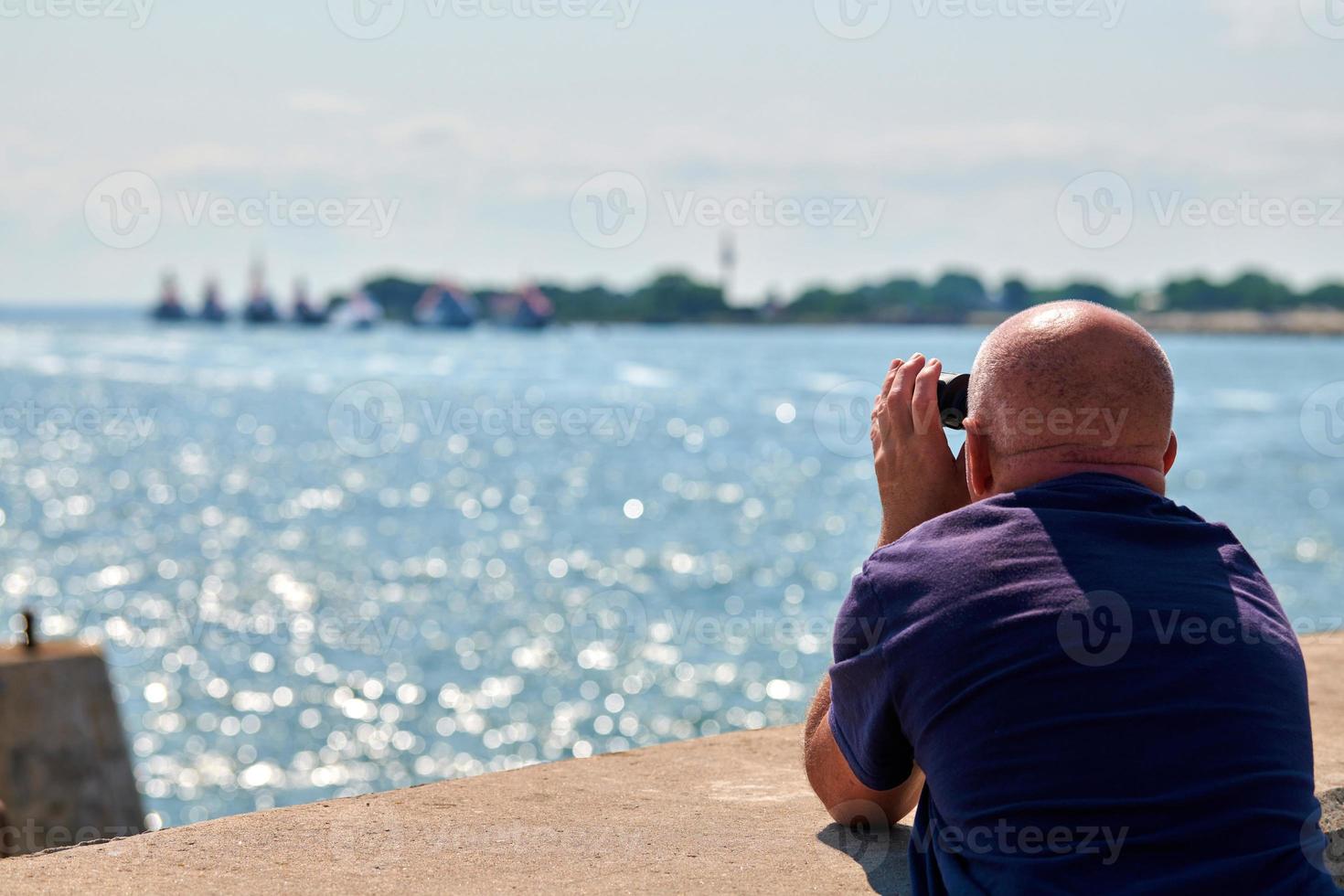 ouderen kaal Mens op zoek door kijker Bij oorlog schepen gedurende marine- optocht Bij blauw Baltisch zee foto