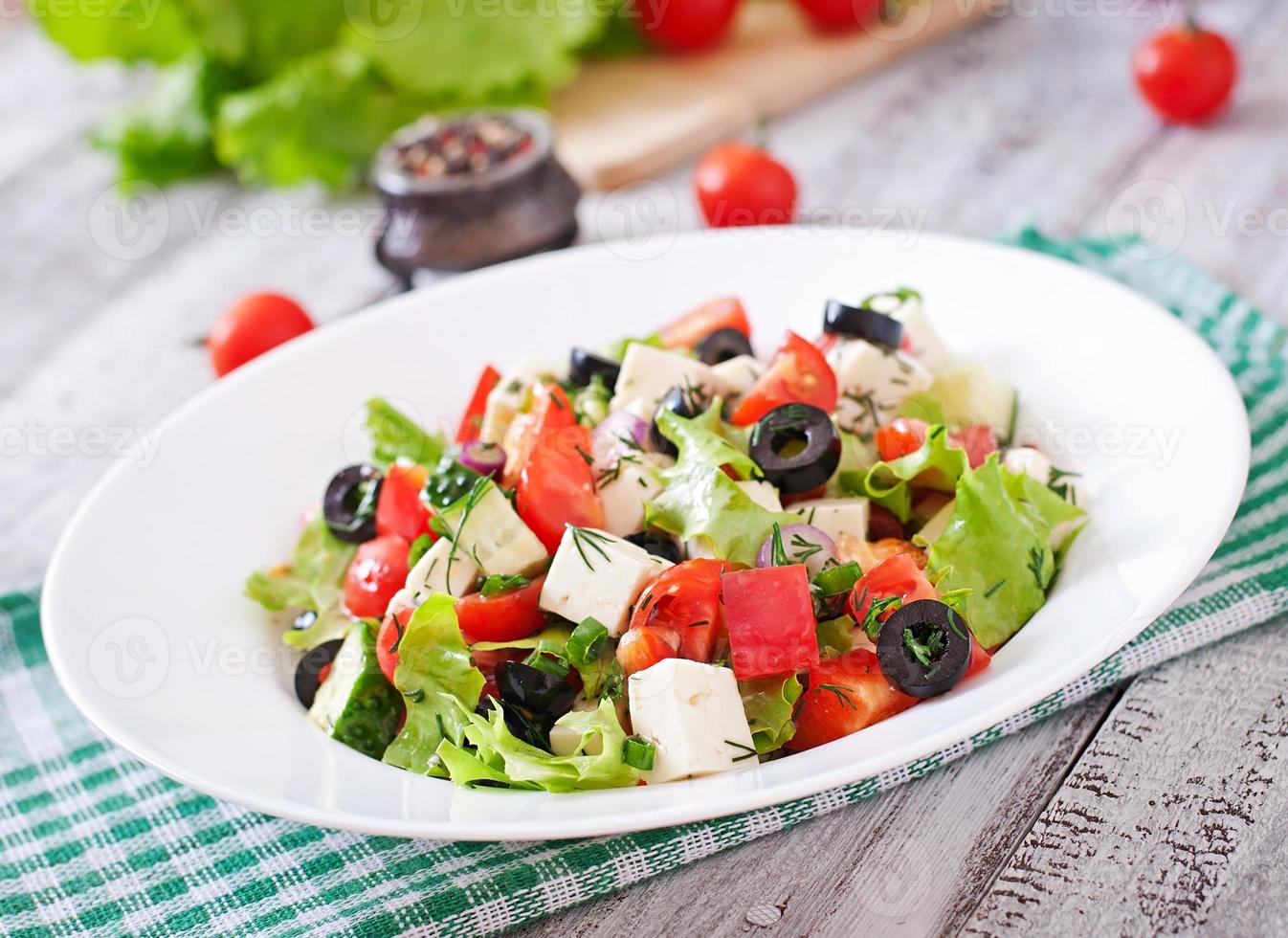Griekse salade met verse groenten, fetakaas en zwarte olijven foto