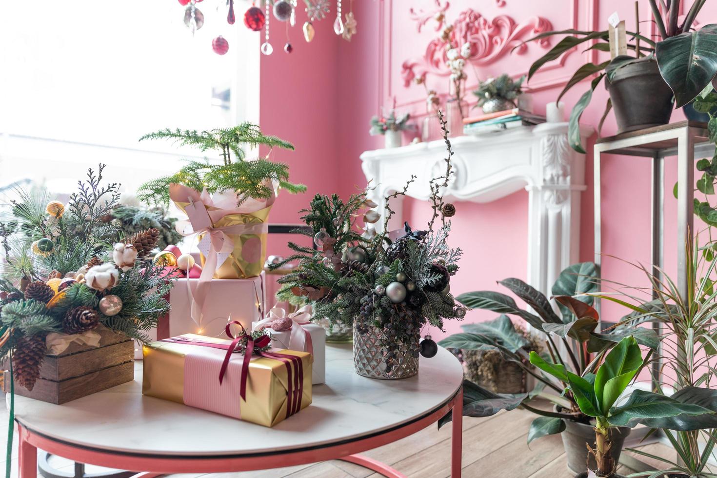 Kerstmis composities van natuurlijk Spar en geschenk dozen en met Kerstmis cadeaus in een elegant roze interieur foto