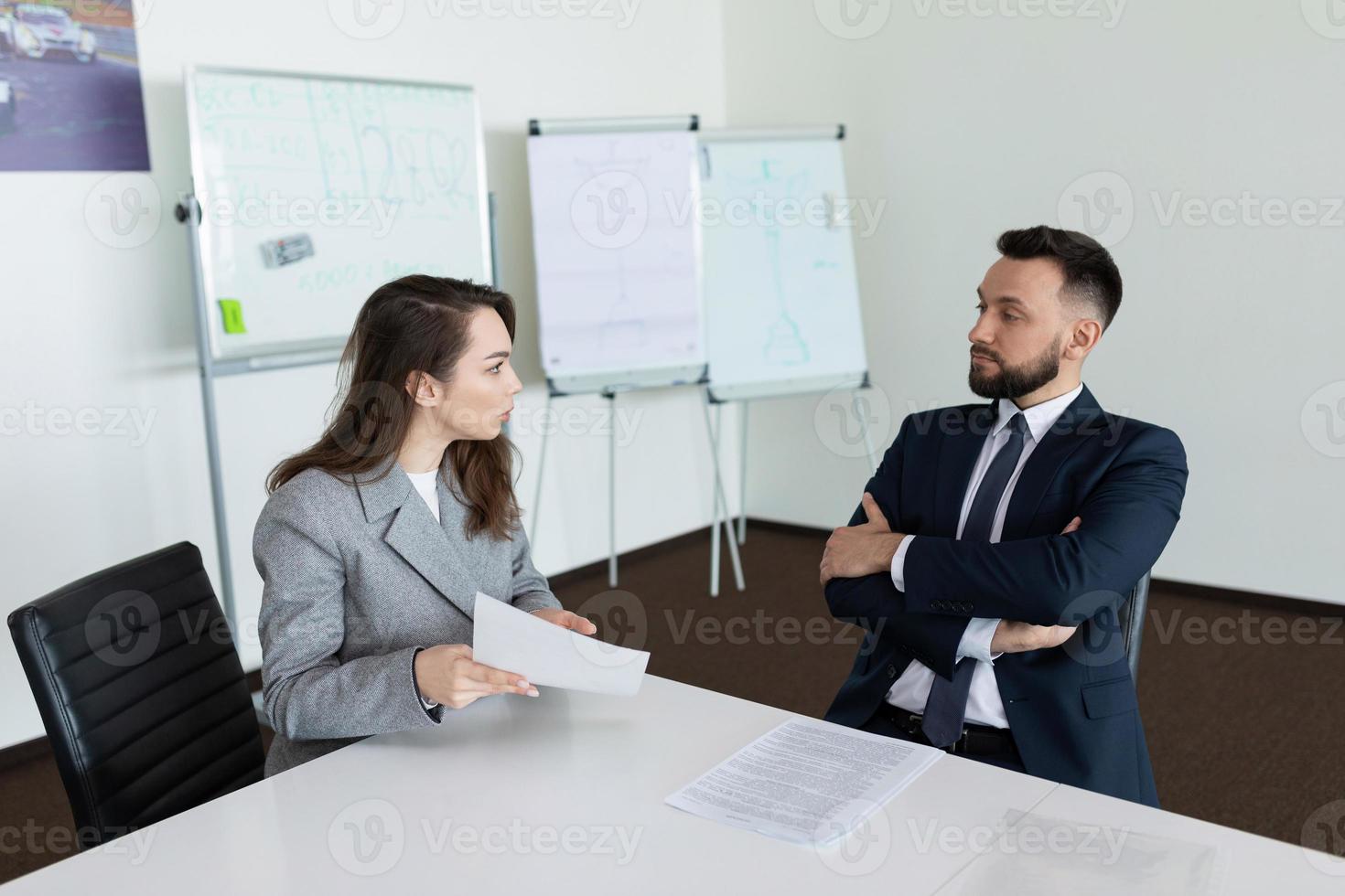 vergadering in de vergadering kamer van twee bedrijf medewerkers in bedrijf pakken, concept van geslaagd bedrijf onderhandelingen foto