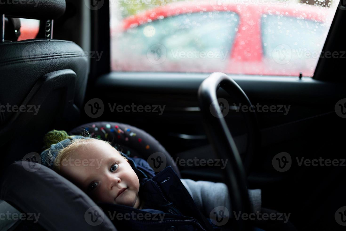 baby zittend in een auto in een vervoerder, foto met diepte van veld. kind veiligheid concept