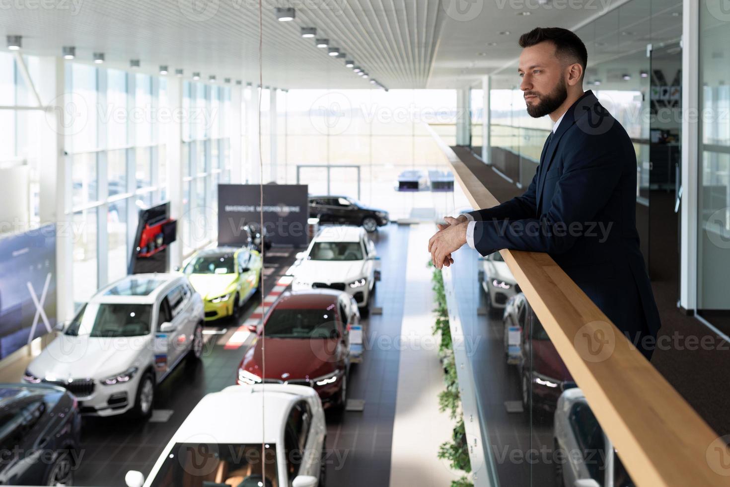 zakenman kiest een nieuw uitvoerend klasse auto in een handelaar toonzaal, concept auto leasing foto
