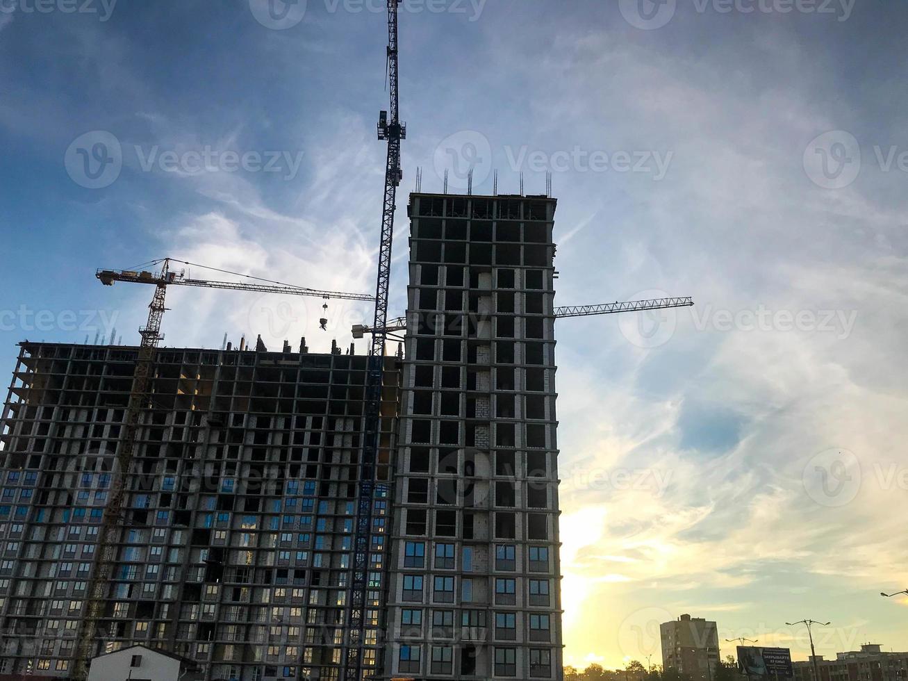 bouw kranen zijn oprichten nieuw huizen van blokken. nieuw constructies, plaatsen van leven van mensen. gebouw stedelijk landschap. creatie van een nieuw kwartaal in de stad centrum foto