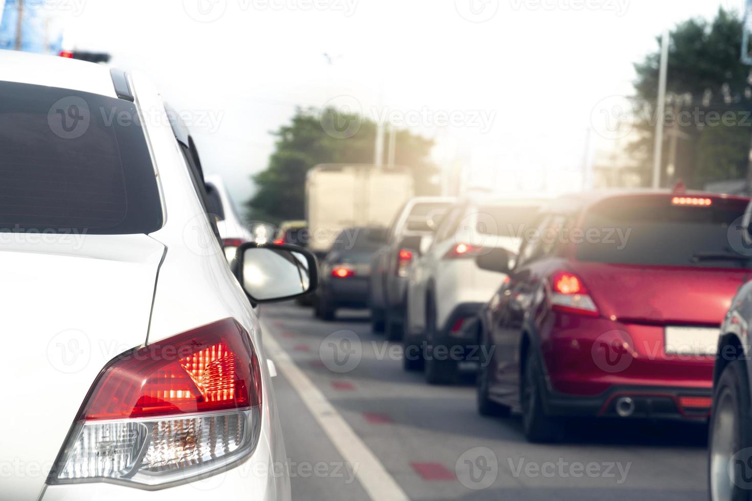 achterzijde kant van wit auto Aan de asfalt weg rubriek naar de doel van de reis. op reis voor werk gedurende stormloop uur. milieu wazig van andere auto's in de stad. foto