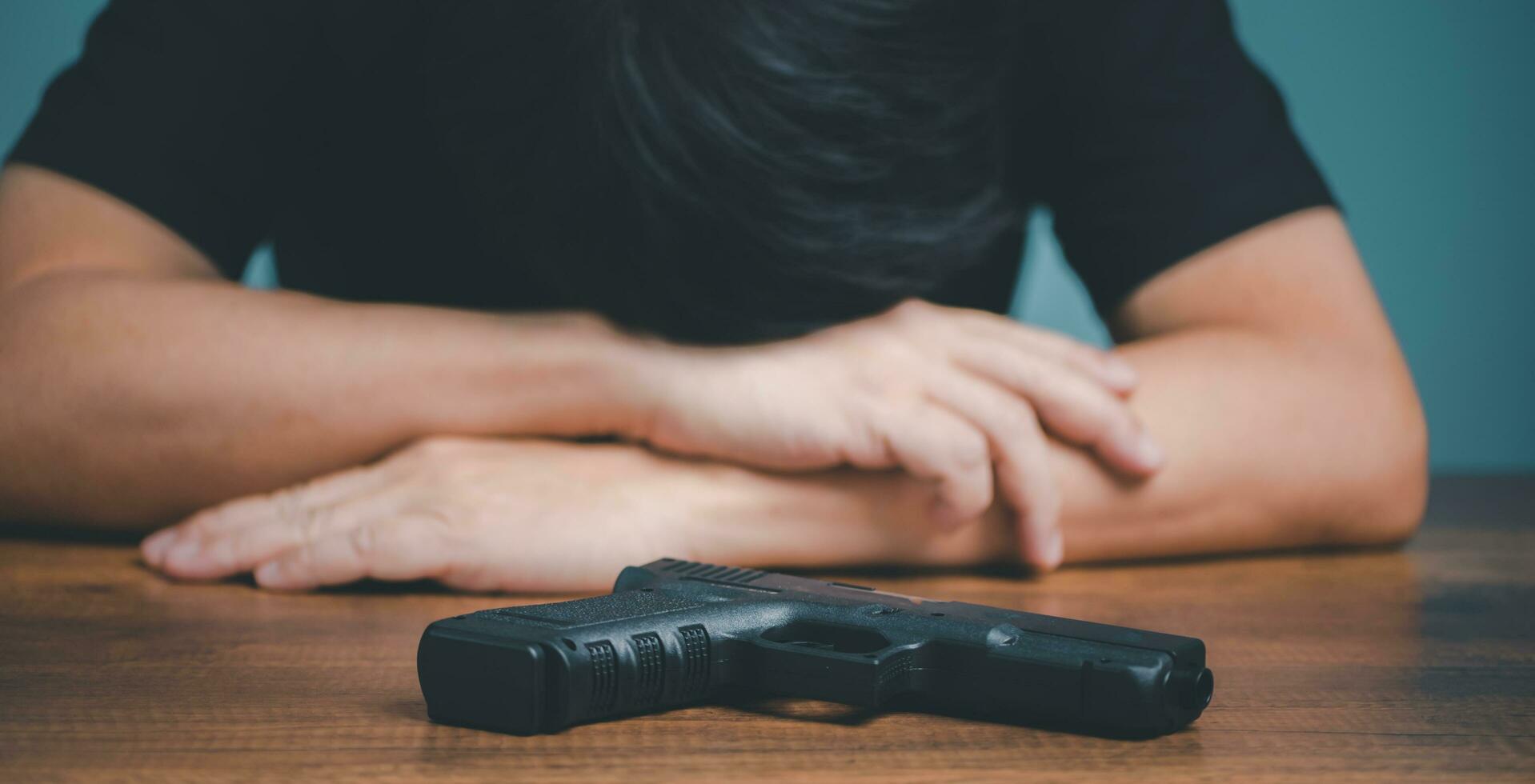 verdrietig en depressief zakenman met geweer Aan de bureau. foto