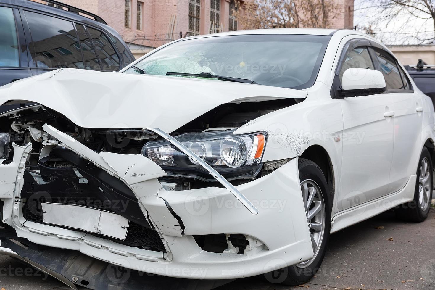 voorkant van wit auto krijgen beschadigd door ongeluk Aan de weg foto