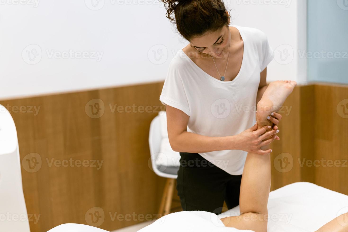 vrouw van middelbare leeftijd met een beenmassage in een schoonheidssalon. foto