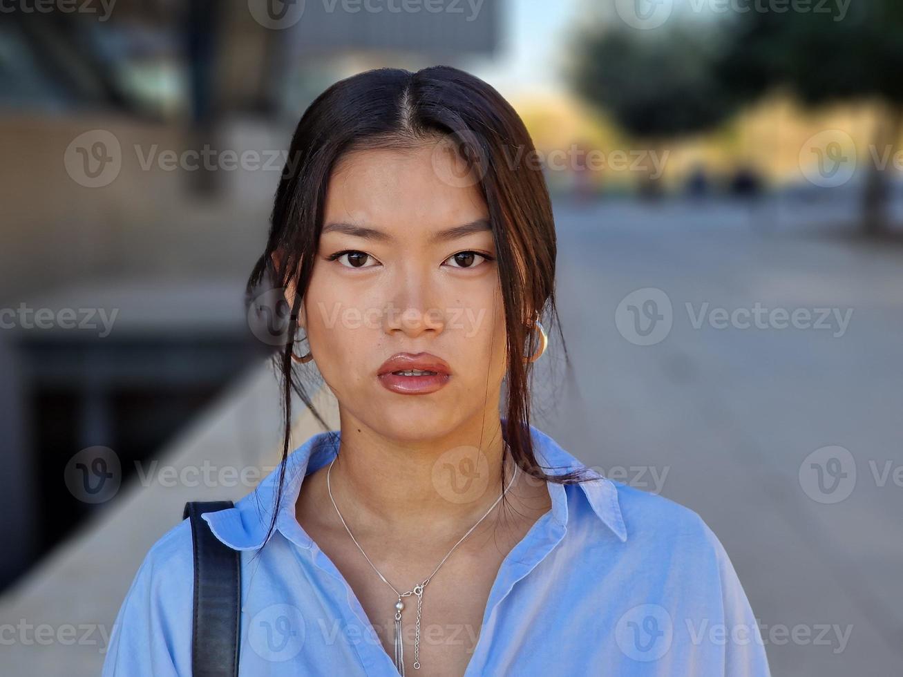 Chinese meisje op zoek Bij camera met een echt uitdrukking in stedelijk achtergrond. foto