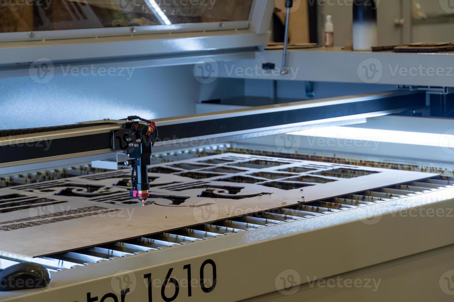 laser snijdend machine, snijdend hout lakens, terwijl een Mens records de werkwijze, Mexico foto