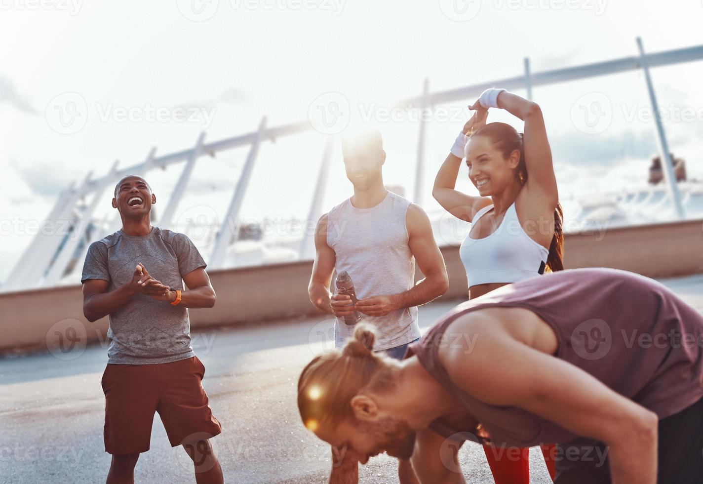 groep van jong mensen in sport- kleding glimlachen terwijl oefenen buitenshuis foto