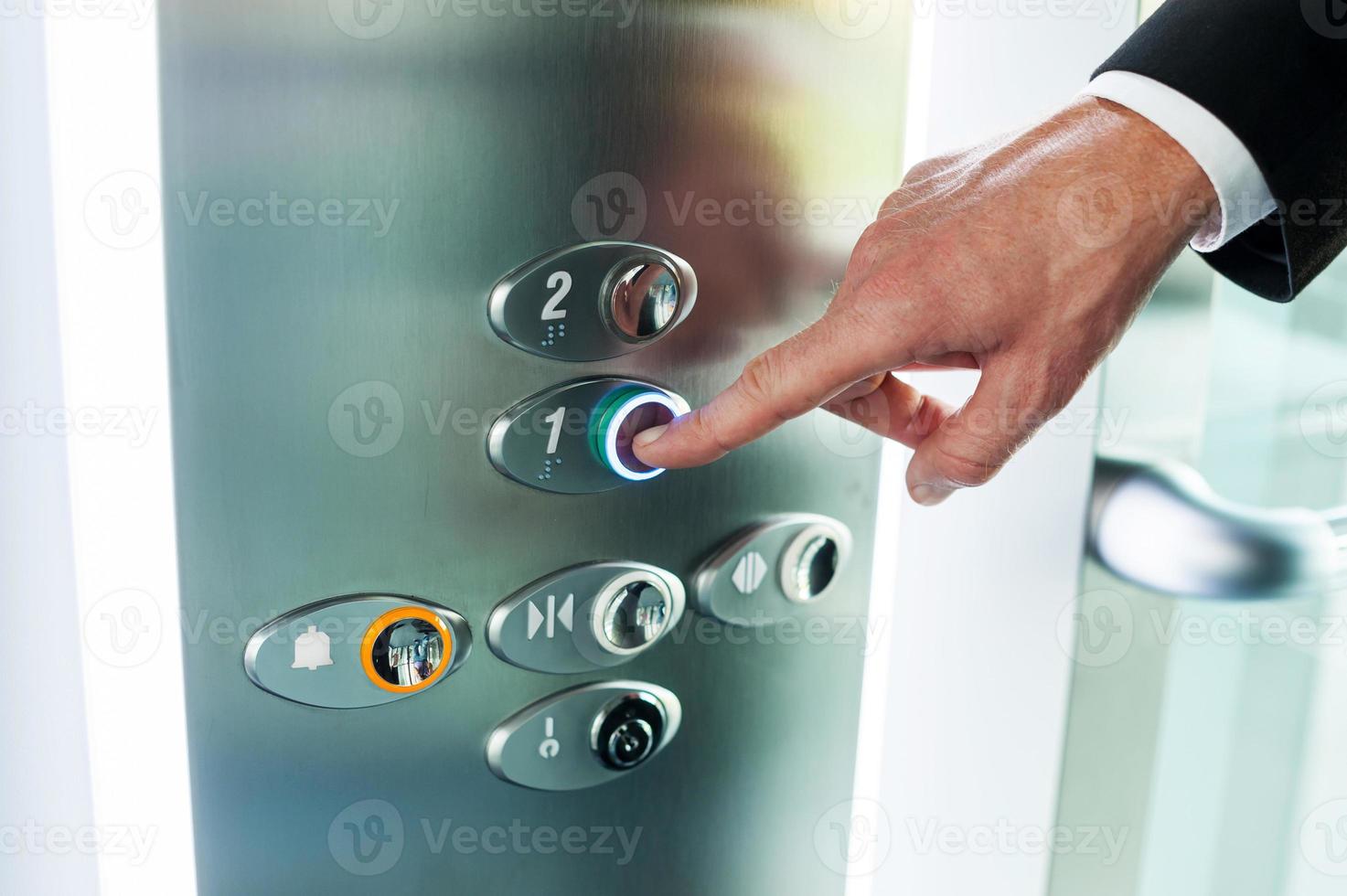 Mens voortvarend knop. detailopname van mannetje hand- voortvarend knop van lift foto