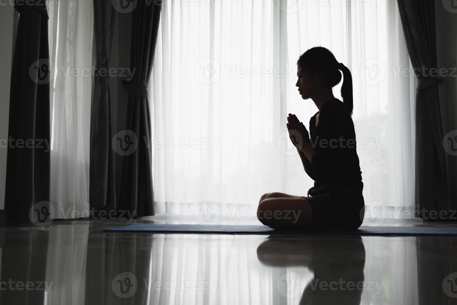 silhouet van vrouw gebed positie, bidden handen met geloof in religie en geloof in god Aan donker achtergrond. macht van hoop of liefde en toewijding. namaste of namaskar handen gebaar. foto