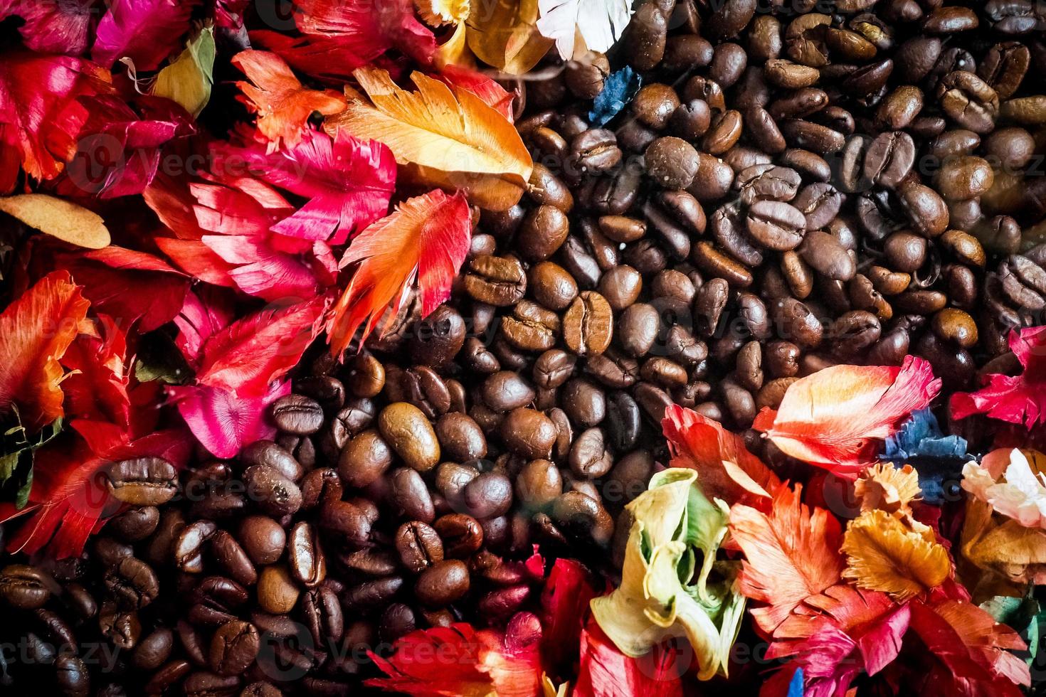 de achtergrondafbeelding is gemaakt van koffiebonen versierd met bloemen. achtergrondconcept voor coffeeshop foto