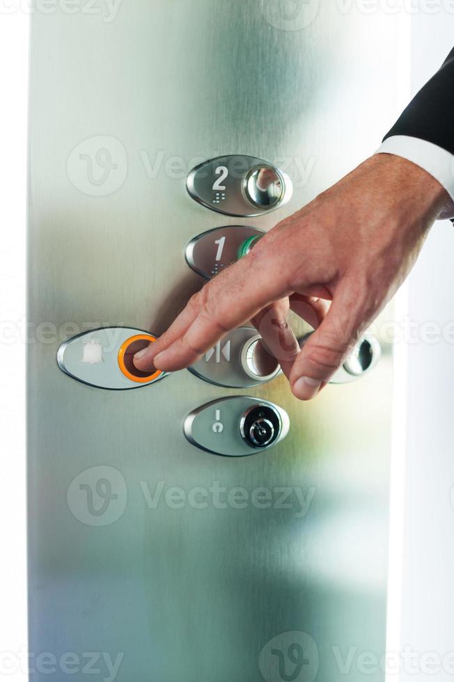 Mens voortvarend knop. detailopname van mannetje hand- voortvarend knop van lift foto