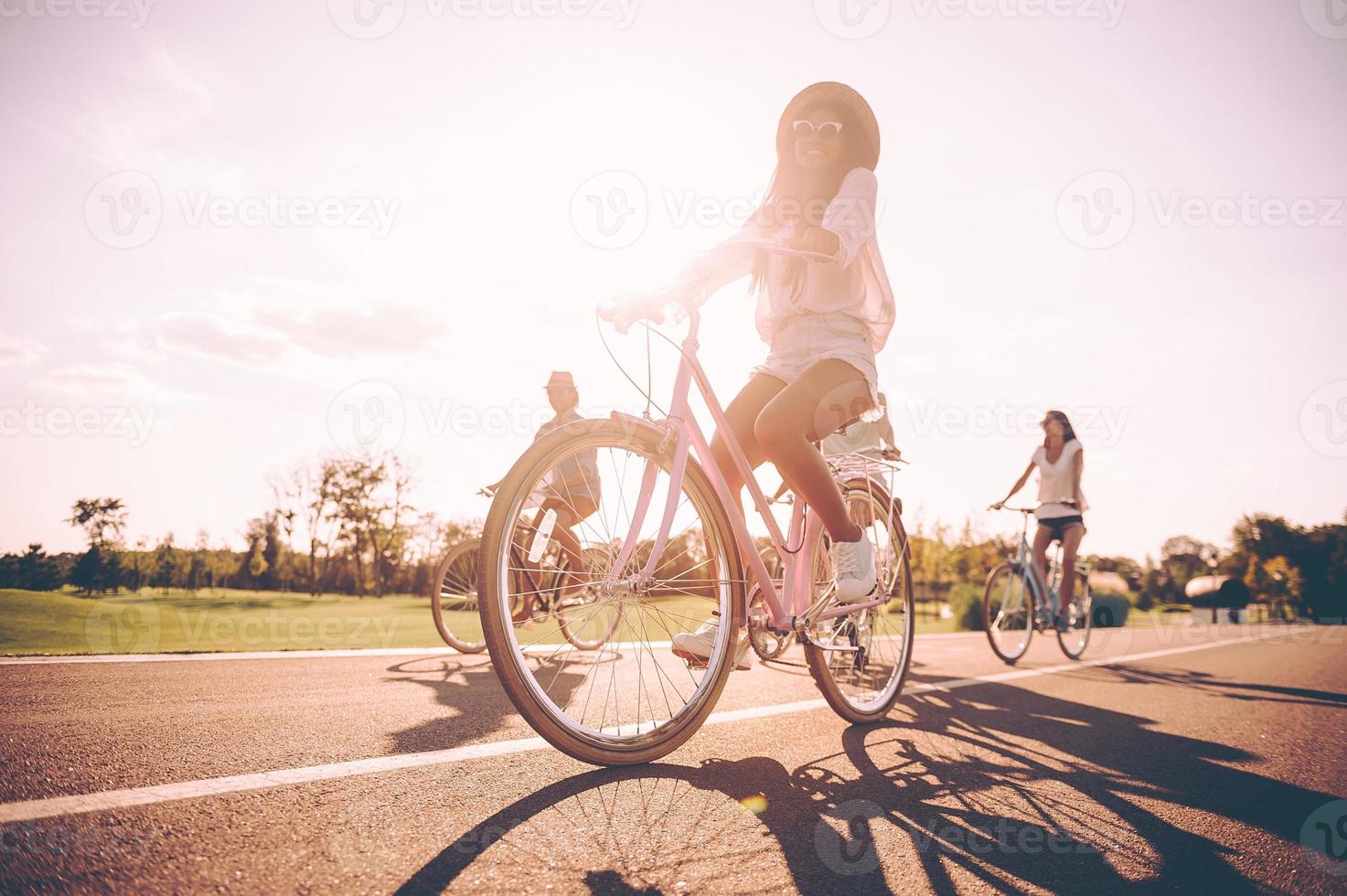 wielersport met plezier. laag hoek visie van jong mensen rijden fietsen langs een weg en op zoek gelukkig foto