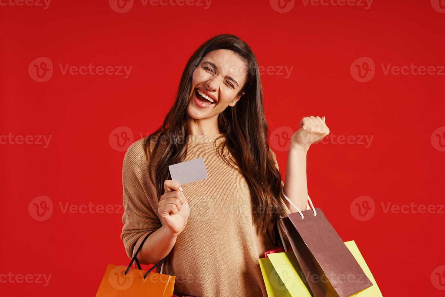 gelukkig jong vrouw in gewoontjes kleding draag- boodschappen doen Tassen en credit kaart foto