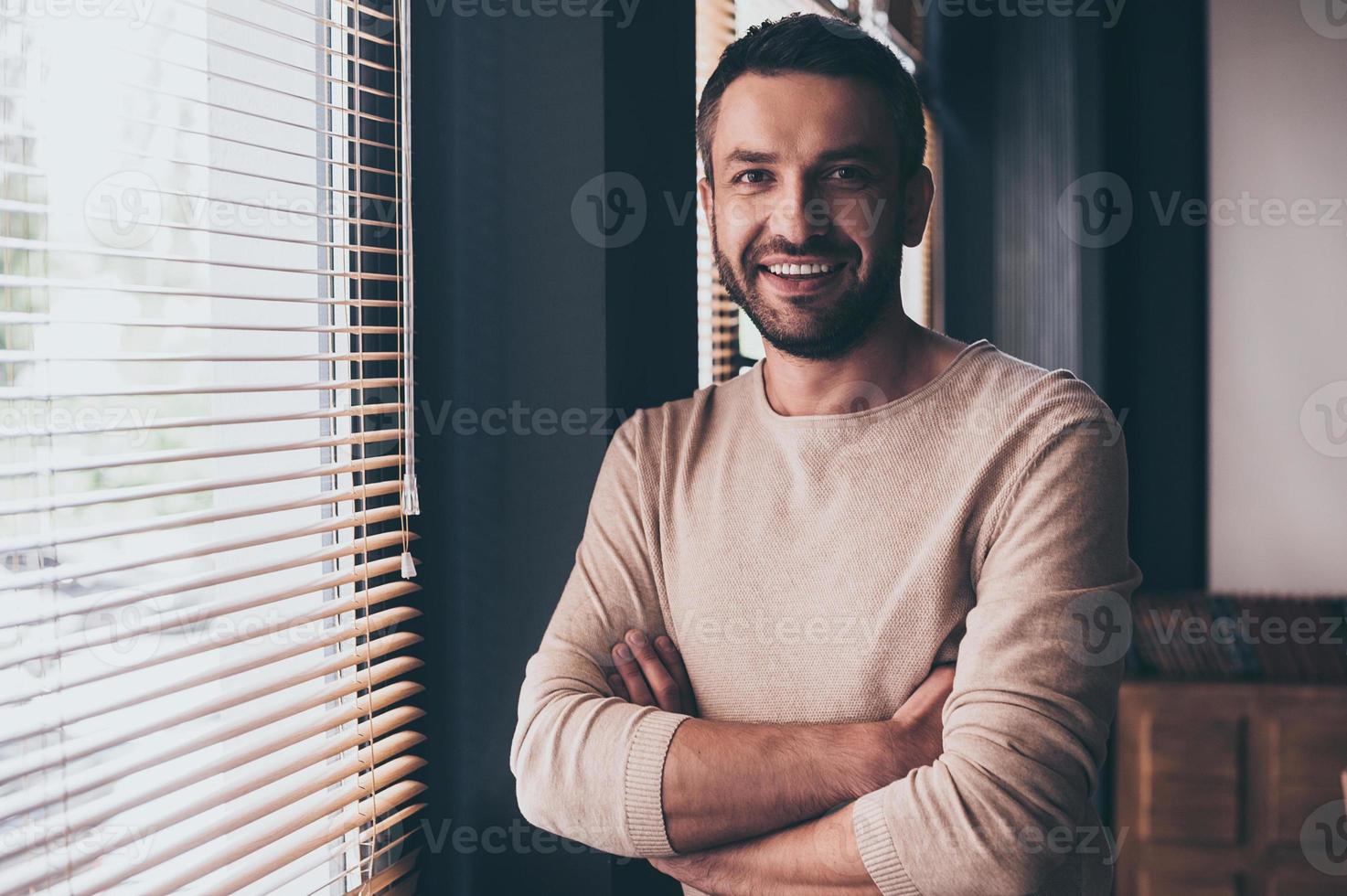 houden lachend. knap jong vrolijk Mens op zoek Bij camera met glimlach terwijl staand Bij zijn werken plaats foto