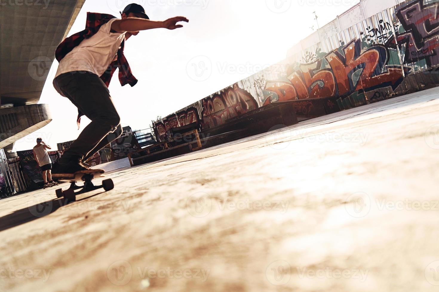 in beweging snel. vol lengte van jong Mens skateboarden terwijl hangende uit Bij de vleet park buitenshuis foto