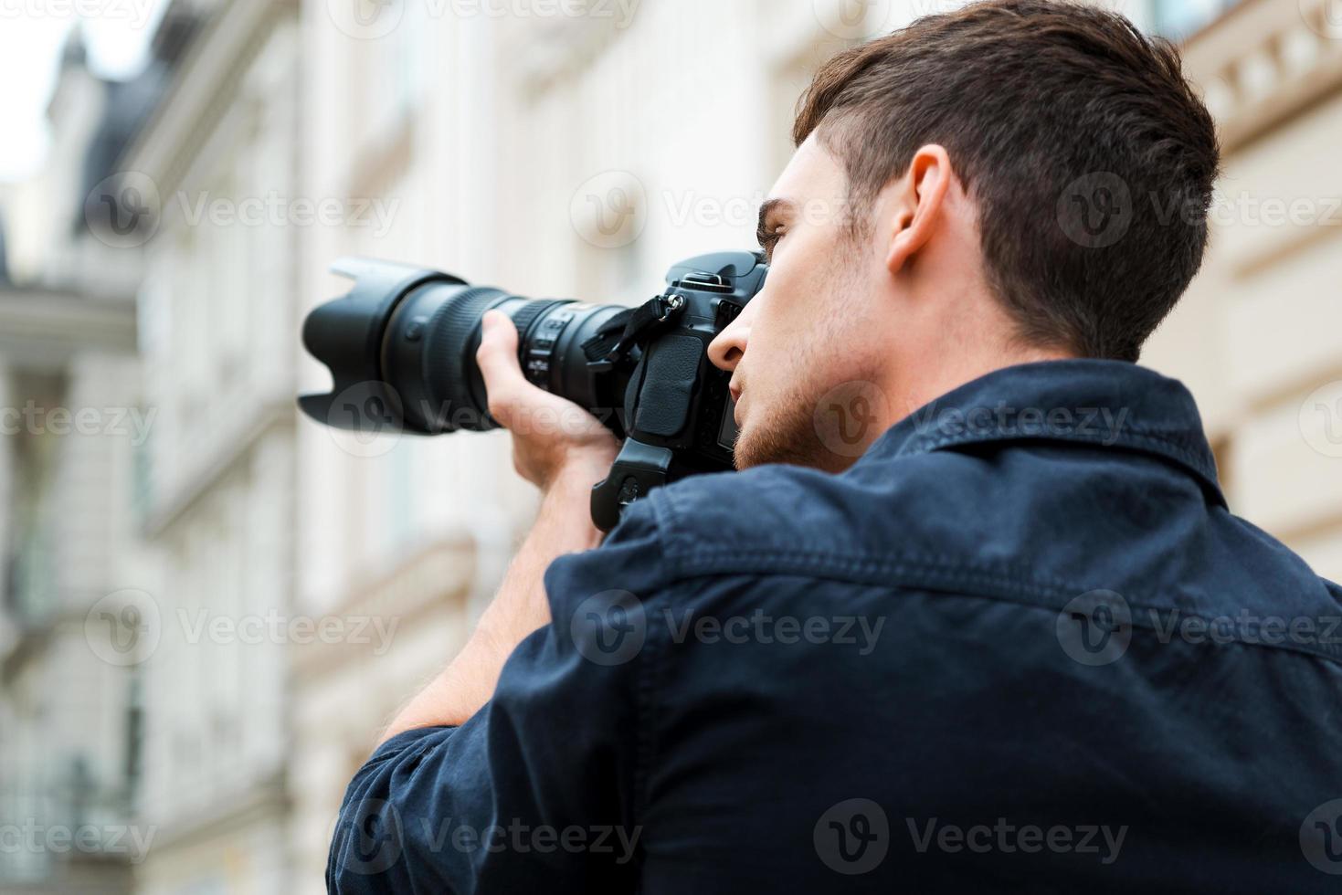 vastleggen de schoonheid. achterzijde visie van jong Mens fotograferen iets terwijl staand buitenshuis foto