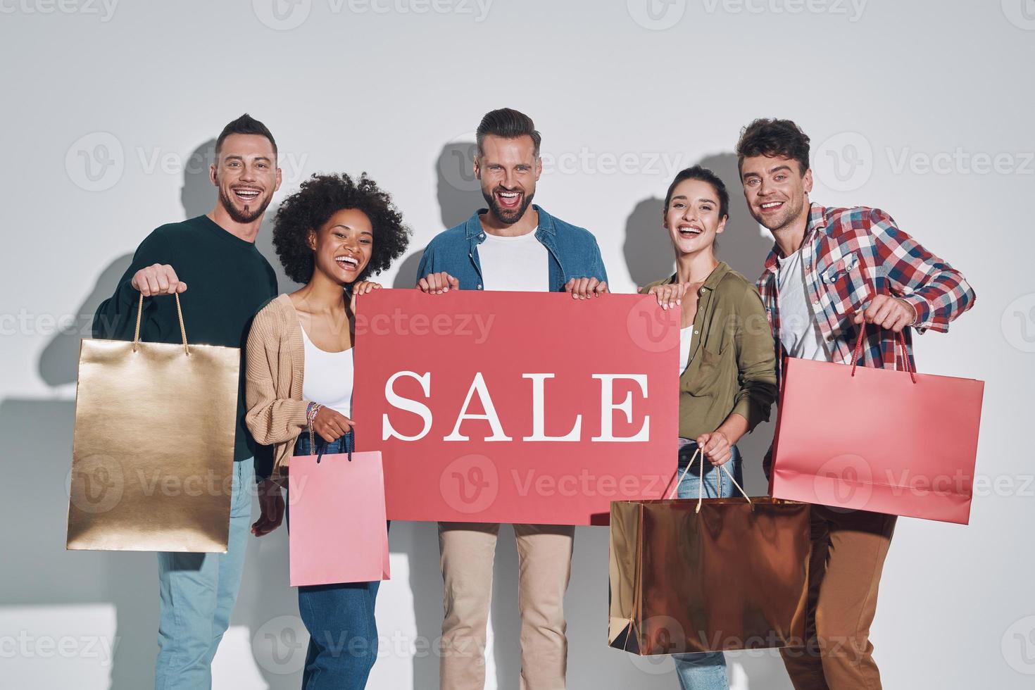 groep van jong mooi mensen in gewoontjes kleding draag- boodschappen doen Tassen en glimlachen foto