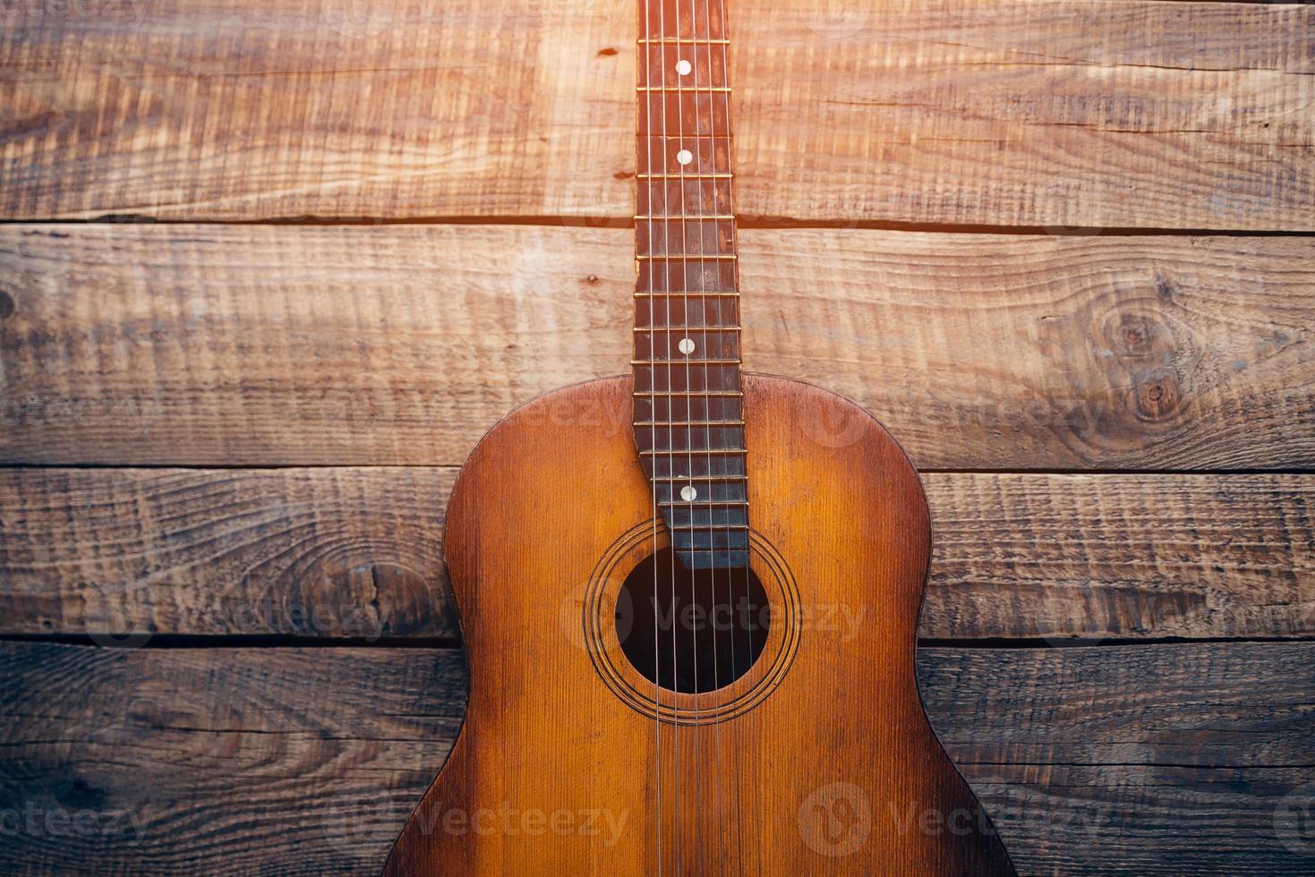 akoestisch gitaar. detailopname van gitaar aan het liegen Aan wijnoogst hout achtergrond foto