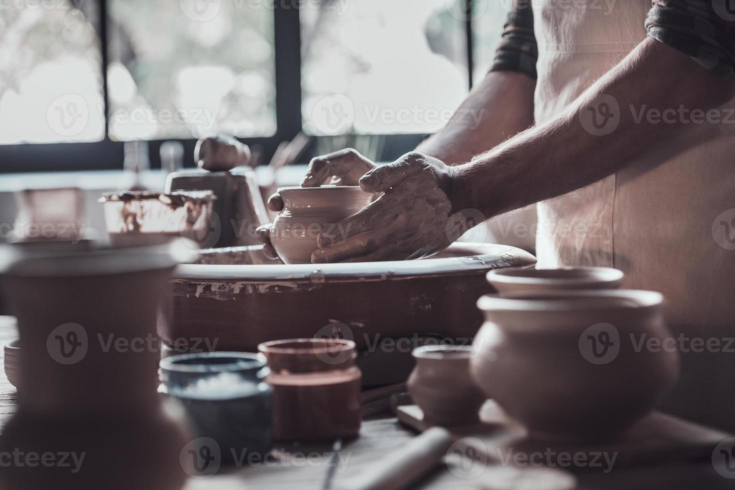 creëren iets speciaal. detailopname van Mens maken keramisch pot Aan de pottenbakkerij wiel foto