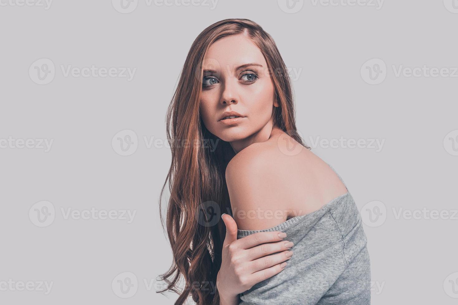 portret van elegantie. studio schot van aantrekkelijk jong vrouw in gewoontjes slijtage tonen haar schouder en op zoek weg foto