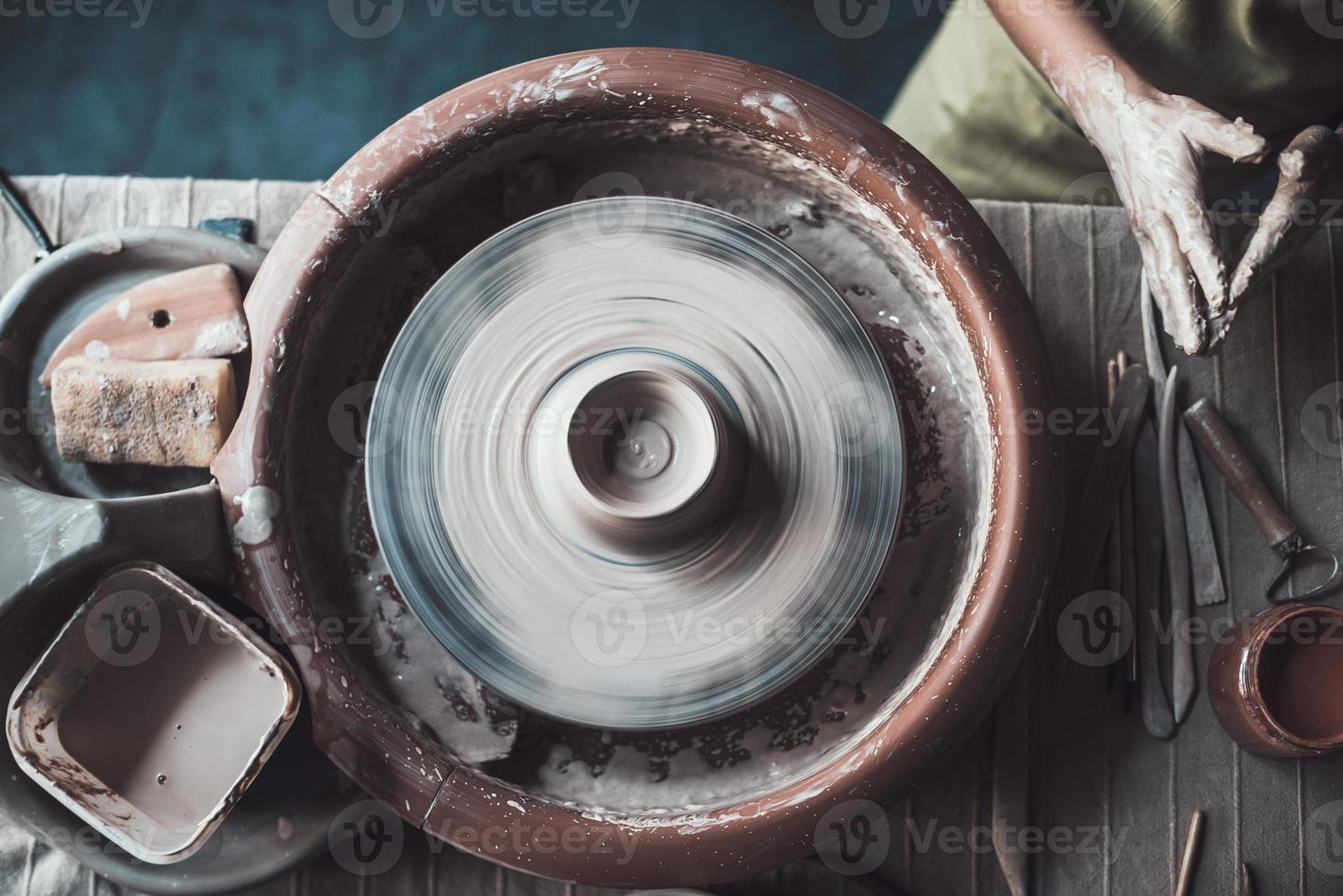 klaar naar maken iets groot. top visie van pottenbakker staand in de buurt pottenbakkerij wiel foto