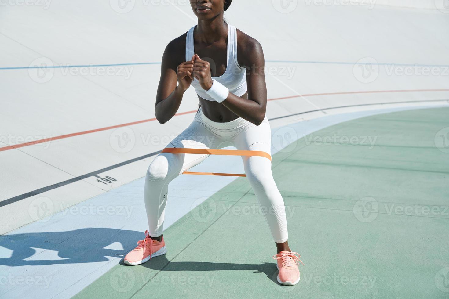 detailopname van zelfverzekerd jong Afrikaanse vrouw in sport- kleding oefenen buitenshuis foto