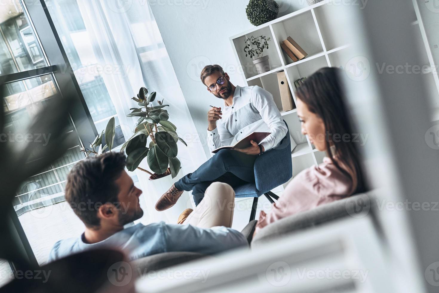 zoeken voor harmonie. top visie van jong getrouwd paar besparing hun huwelijk terwijl zittend Aan de behandeling sessie met psycholoog foto