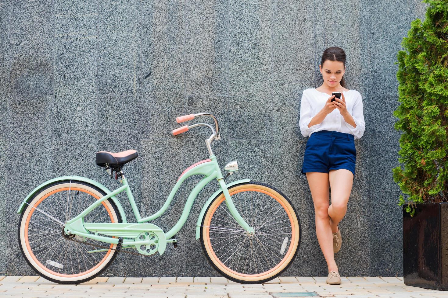 schoonheid met wijnoogst fiets. mooi jong glimlachen vrouw staand in de buurt haar wijnoogst fiets Aan de straat foto