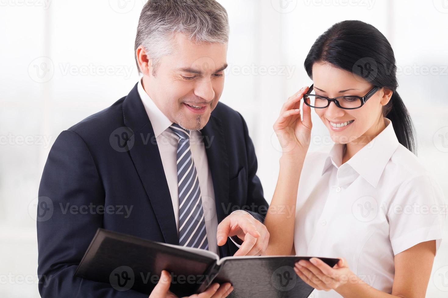 bedrijf mensen Bij werk. twee glimlachen bedrijf mensen Holding Notitie stootkussen en glimlachen foto