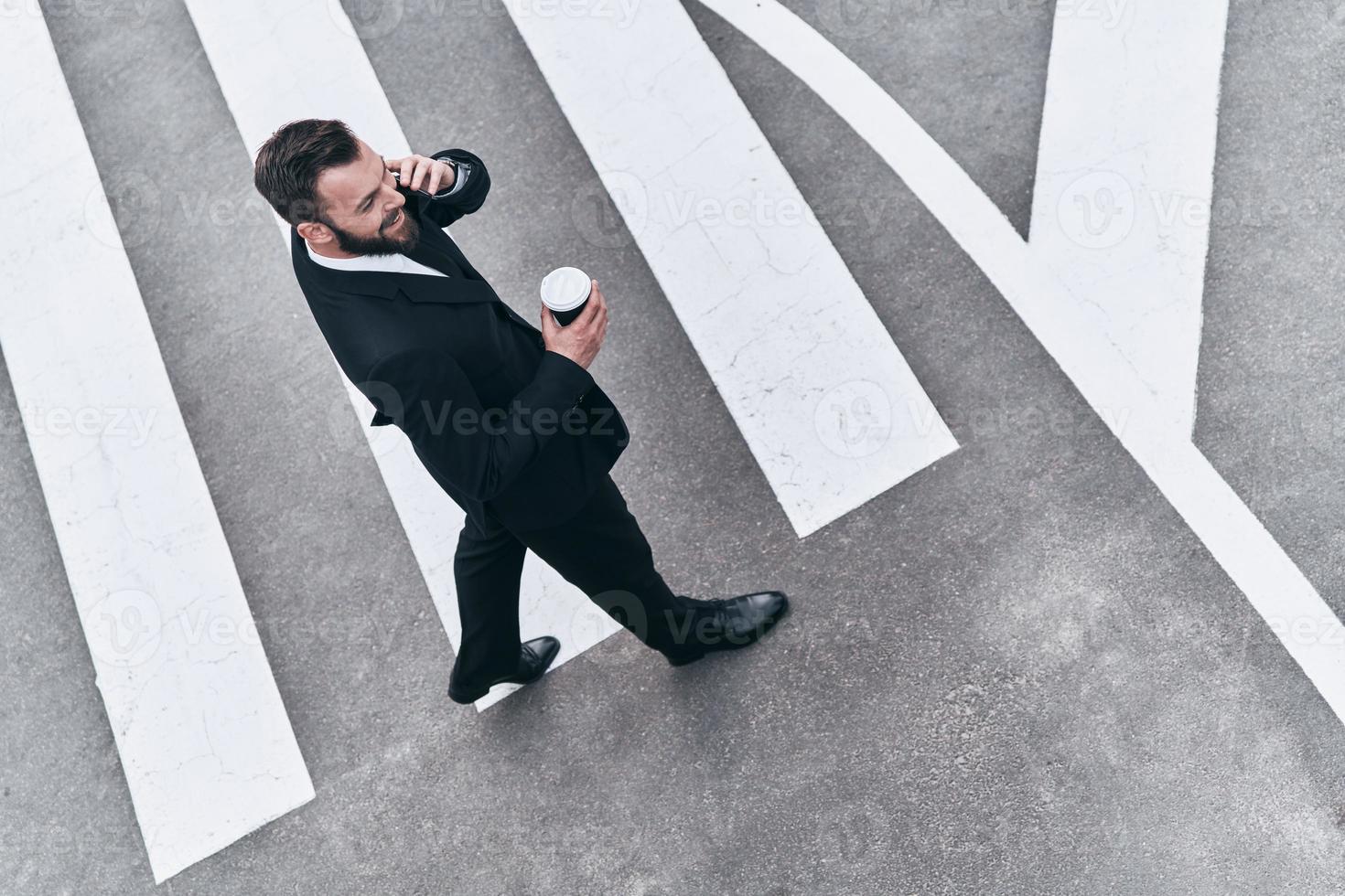 jong bedrijf professioneel. vol lengte top visie van jong Mens in vol pak pratend Aan de telefoon terwijl staand buitenshuis foto