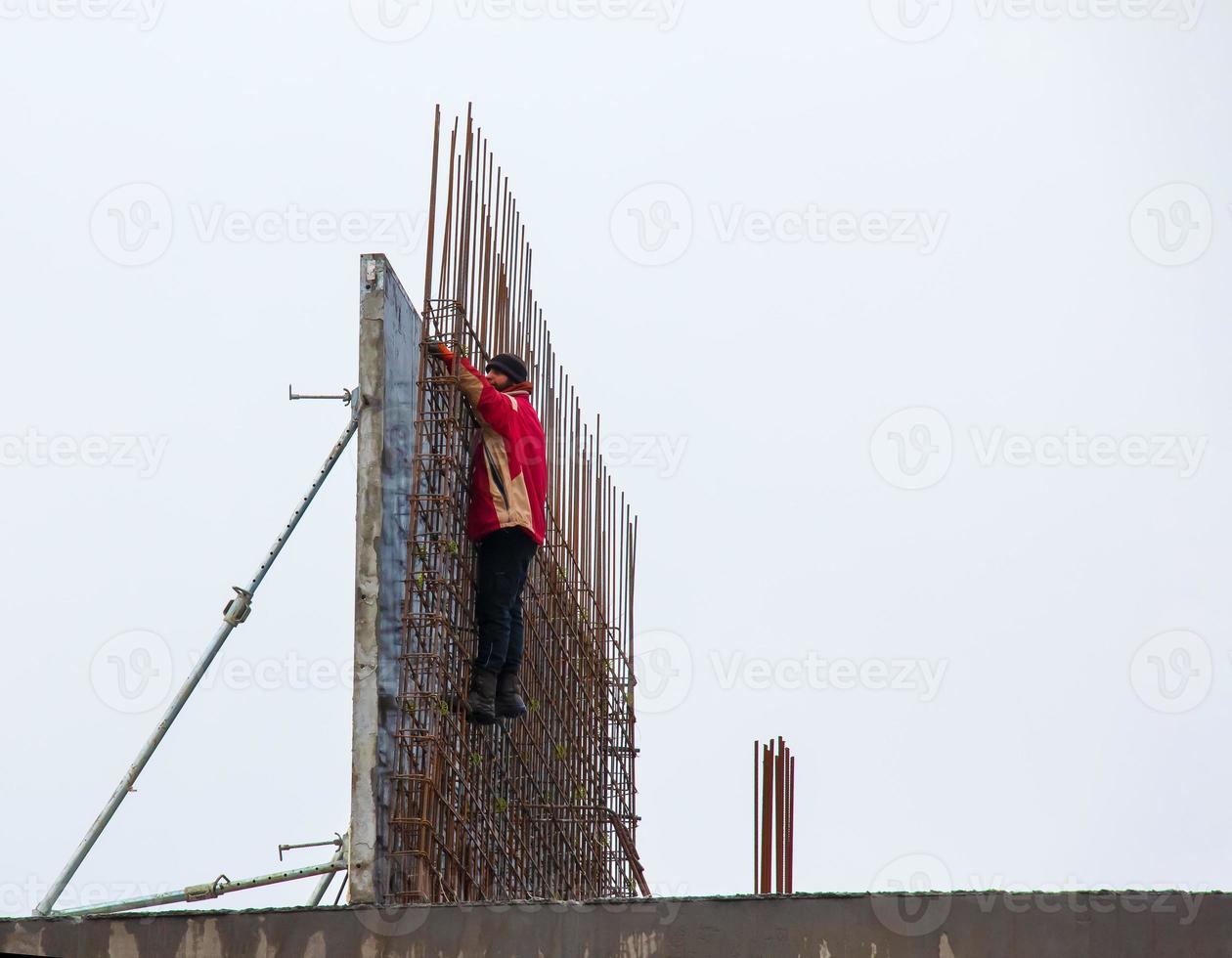 bouw plaats. de arbeider presteert werk Bij hoogte. foto