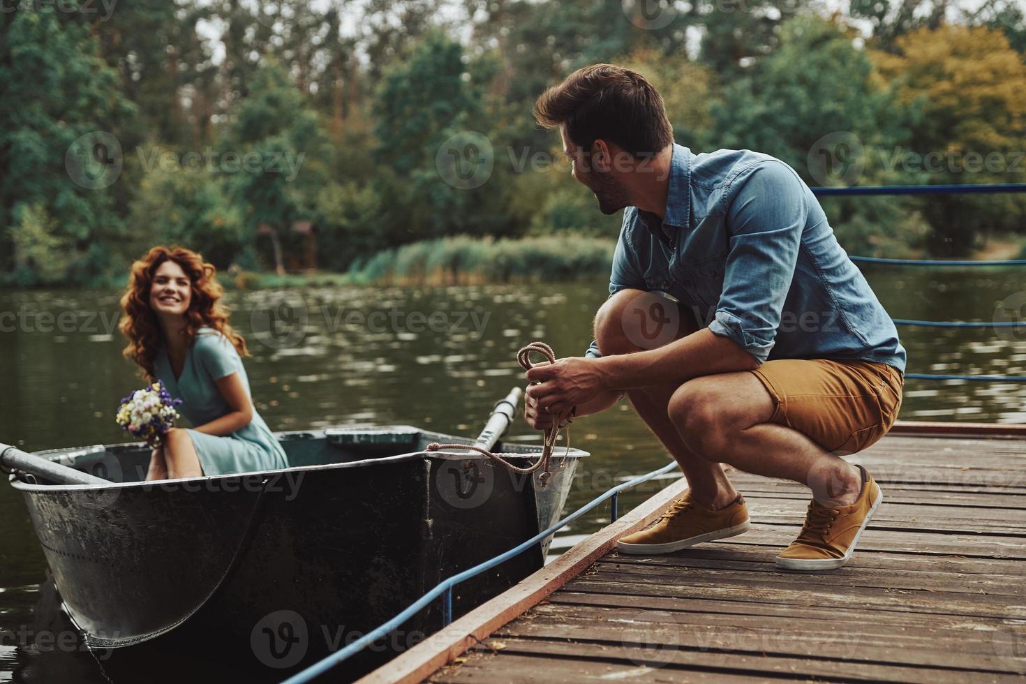 echt liefde. gelukkig jong paar krijgen klaar naar rij een boot terwijl genieten van hun datum buitenshuis foto