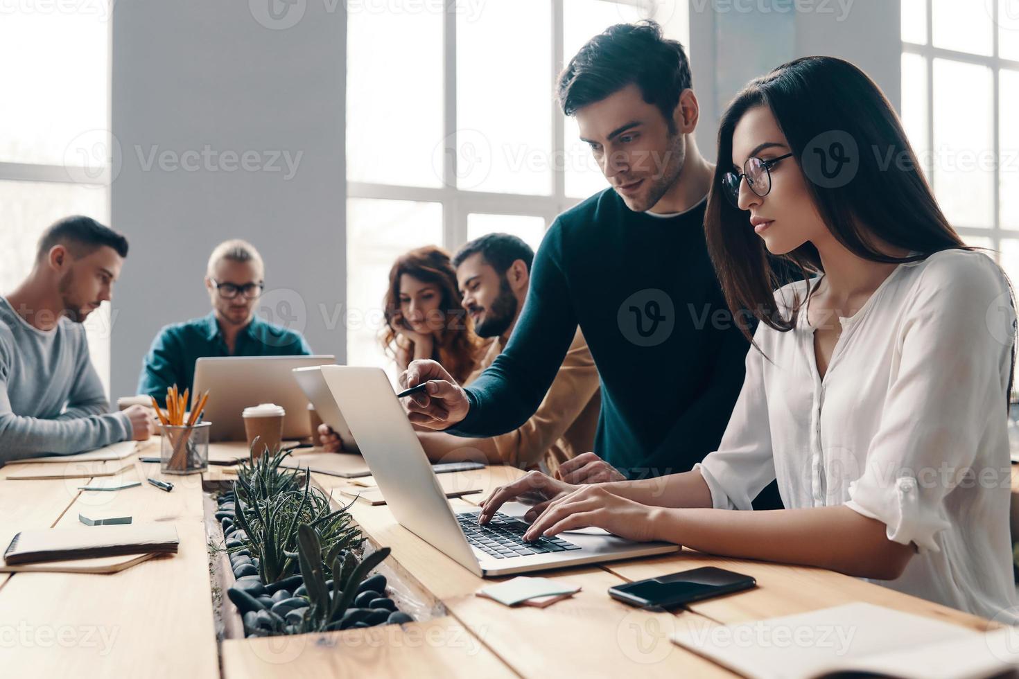 team werken samen. groep van jong modern mensen in slim gewoontjes slijtage gebruik makend van modern technologieën terwijl werken in de creatief kantoor foto