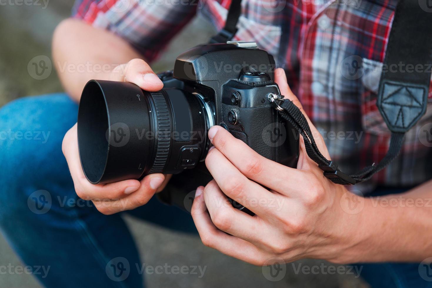 onderzoeken camera voordat schieten. detailopname van Mens onderzoeken zijn digitaal camera terwijl staand buitenshuis foto