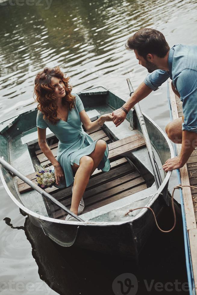 verdrinking in zijn ogen. gelukkig jong paar krijgen klaar naar rij een boot terwijl genieten van hun datum buitenshuis foto