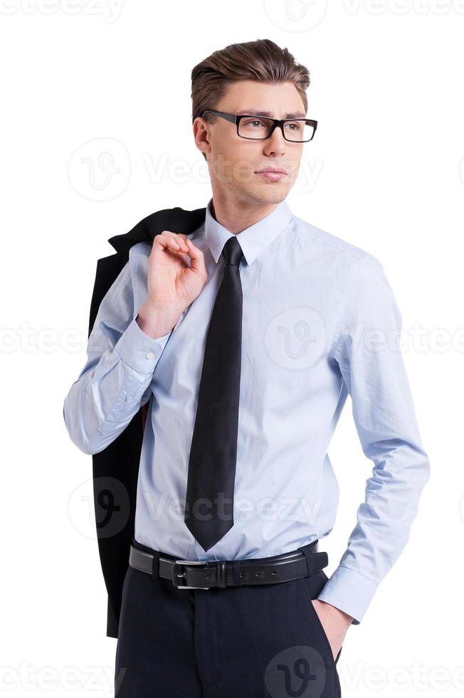 jong en succesvol. zelfverzekerd jong Mens in formele kleding en bril draag- jasje Aan schouder en op zoek weg terwijl staand geïsoleerd Aan wit foto