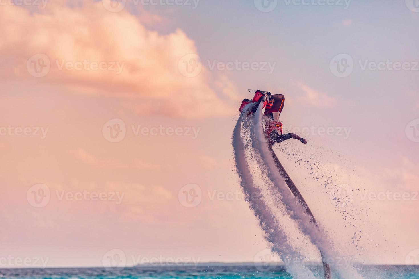 Maldiven eiland zonsondergang. professioneel vlieg bord rijder aan het doen terug omdraaien met tropisch toevlucht eiland achtergrond. zonsondergang sport en zomer werkzaamheid achtergrond, pret water sport foto