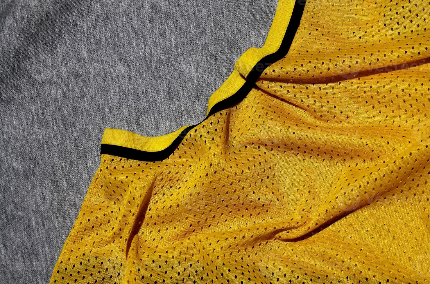 top visie van kleding textiel oppervlak. detailopname verkreukelde kachel en gebreid kleding stof structuur met een dun gestreept patroon. sport kleding kleding stof textuur. gekleurde basketbal overhemd en kachel capuchon foto