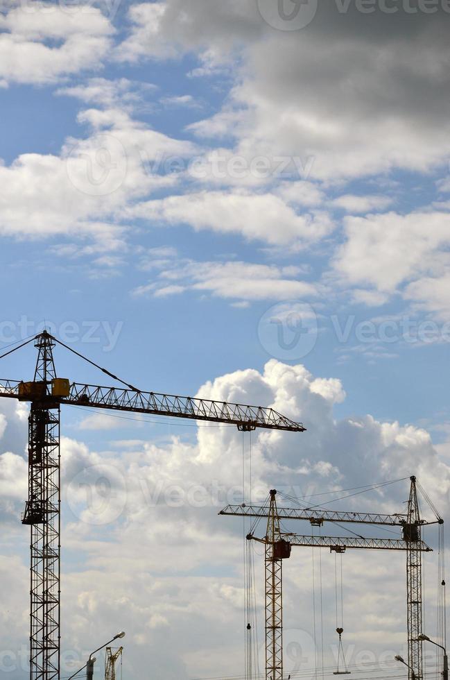 hoog en zwaar bouw kraan torens tegen een blauw lucht foto