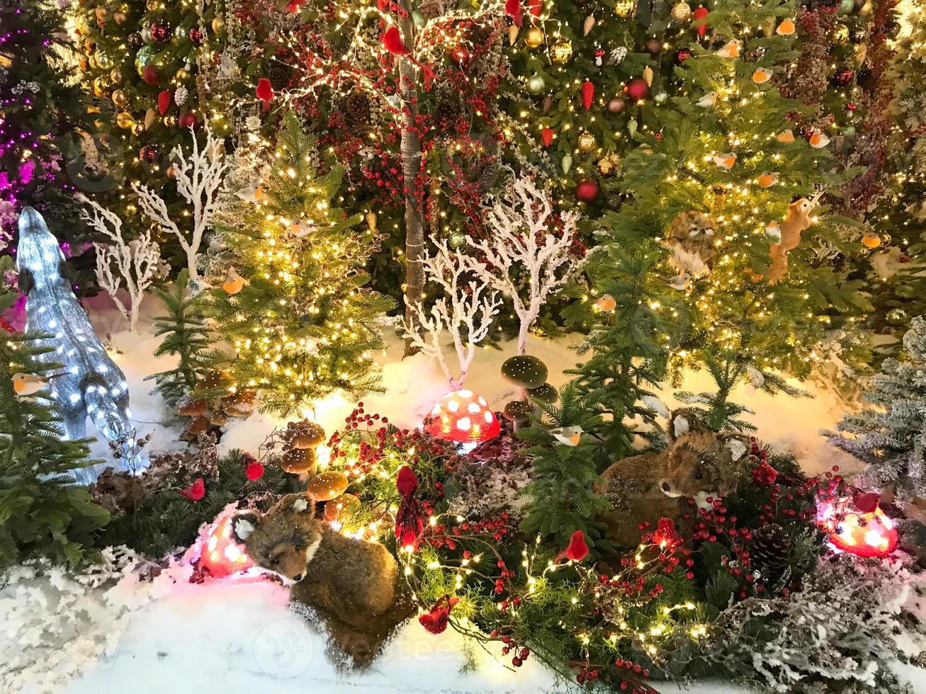 Kerstmis decoratie. schattig decor voor vitrine. hert gemaakt van lichtgevend slingers. De volgende naar hem is een vos, een wasbeer en andere dieren. nieuw jaar in de Woud foto