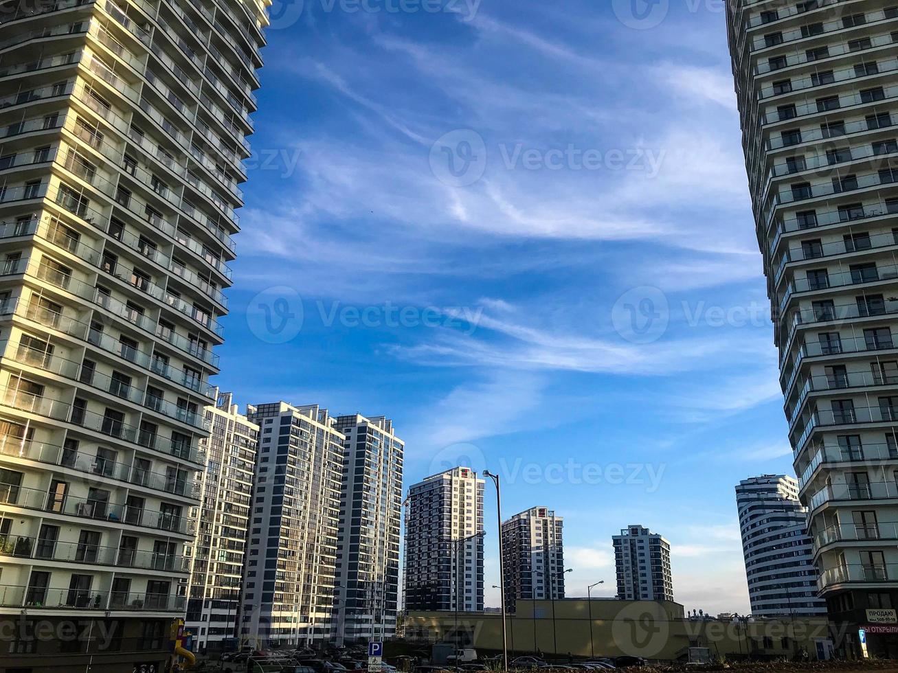 stedelijk landschap. huizen staan in een halve cirkel, wit glas. panoramisch ramen, terrassen. huizen staan in hoogte, van kleinste naar grootste. tegen de blauw lucht Aan een zonnig dag foto