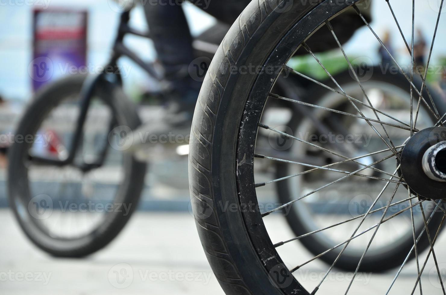 een bmx fiets wiel tegen de backdrop van een wazig straat met wielersport ruiters. extreem sport- concept foto