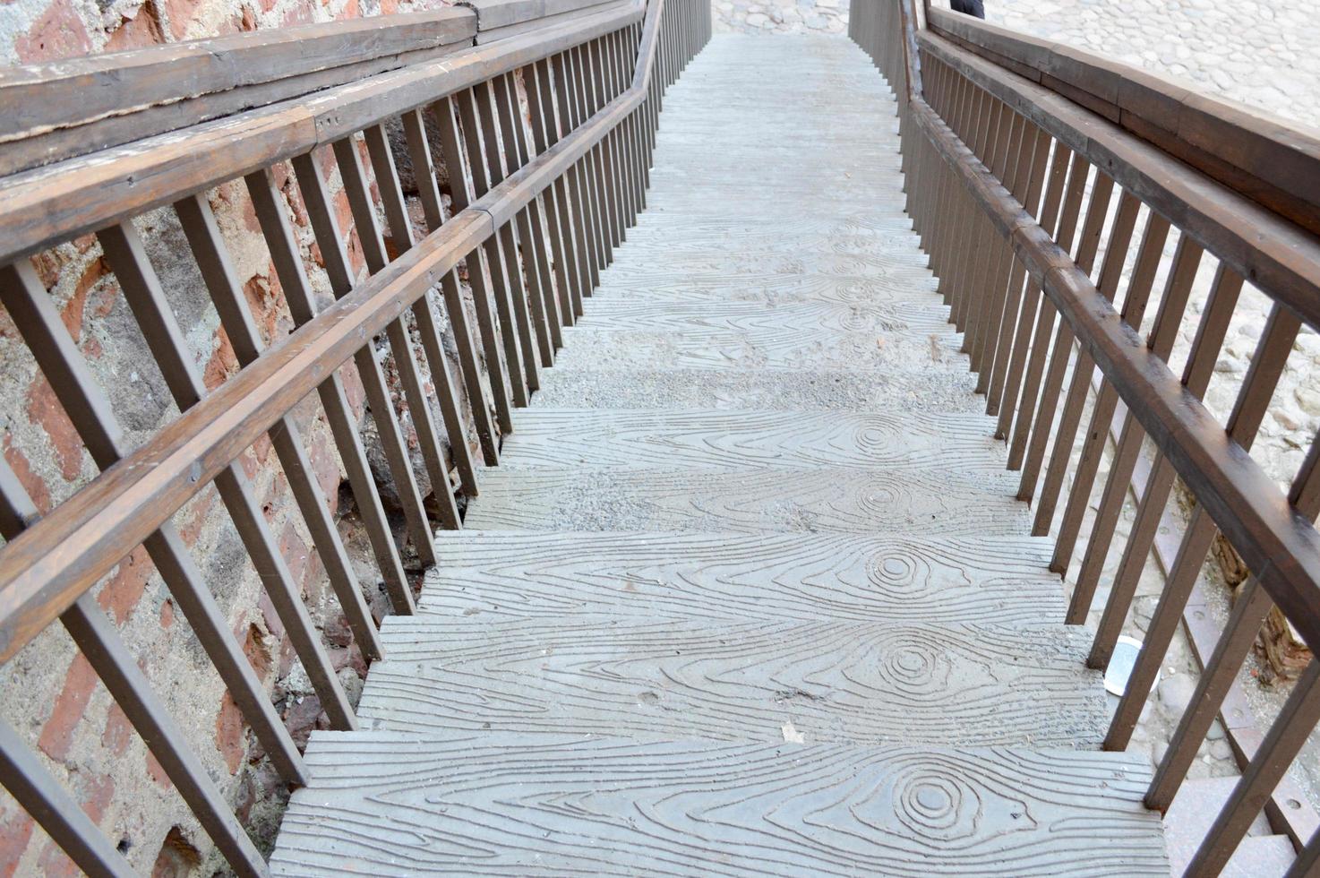 een groot houten bruin trappenhuis leidend naar beneden met stappen en balustrades. de achtergrond foto