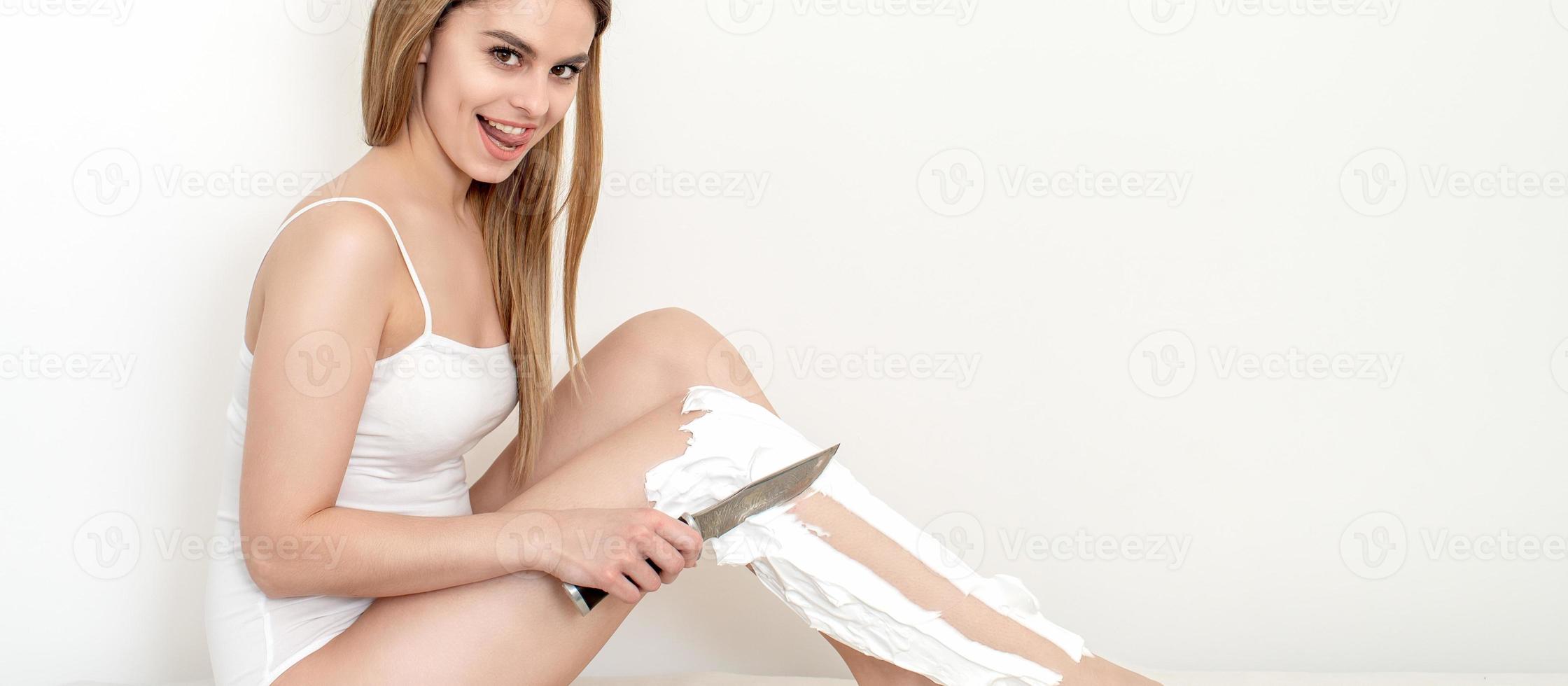 vrouw scheert haar poten met een mes foto