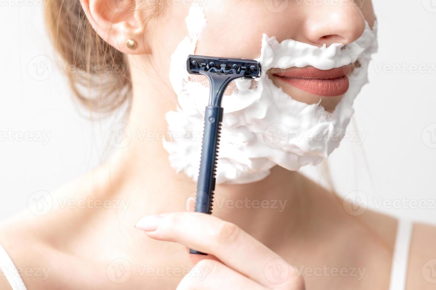vrouw scheren haar gezicht door scheermes foto