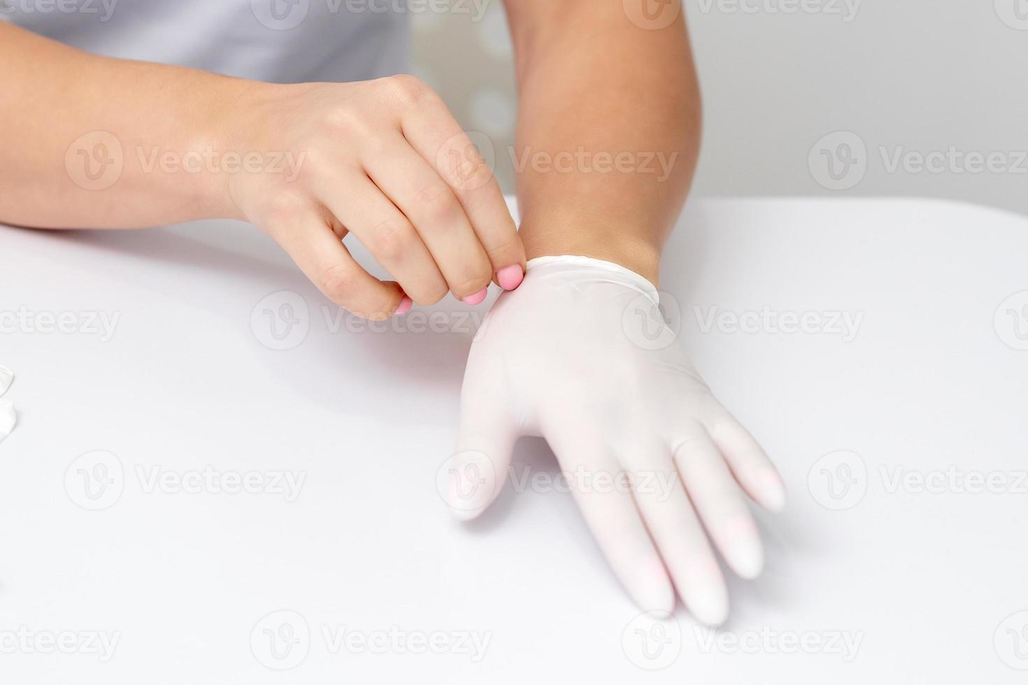 vrouw handen zetten Aan beschermend handschoenen foto